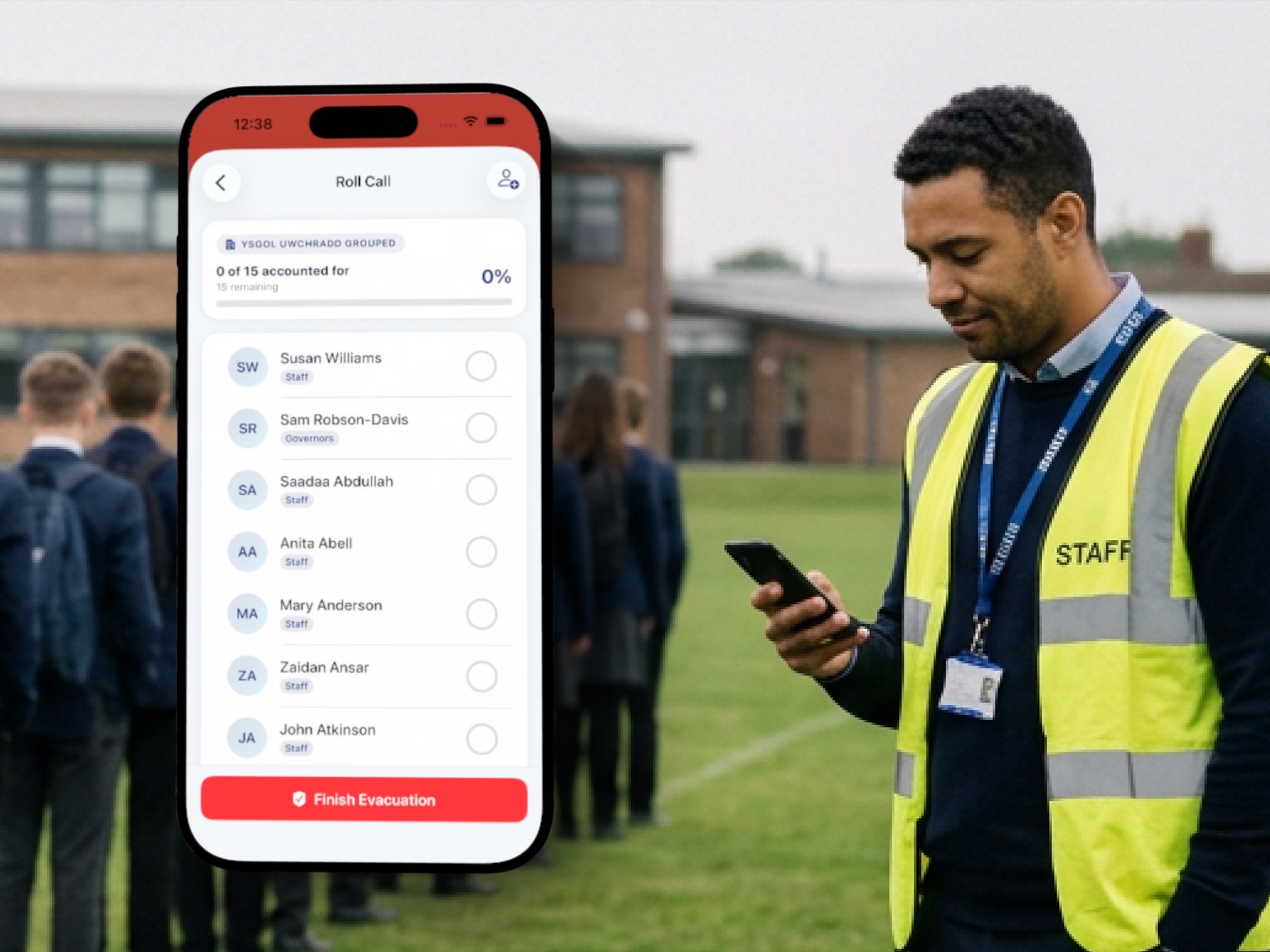 A member of staff in a high-visibility vest using the OnSite evacuation roll-call on a phone, with pupils gathered on the field behind