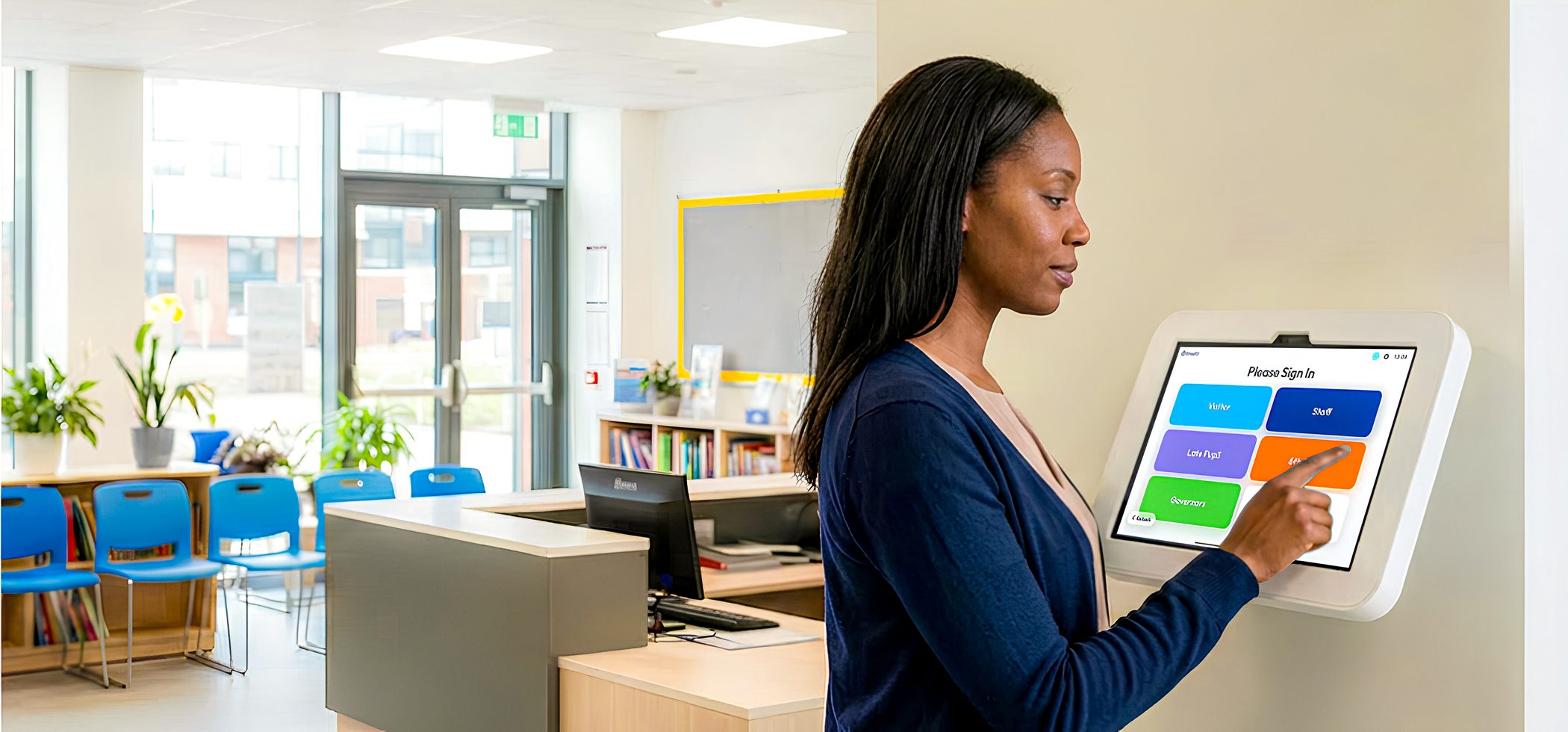 A school receptionist signing a visitor in on OnSite
